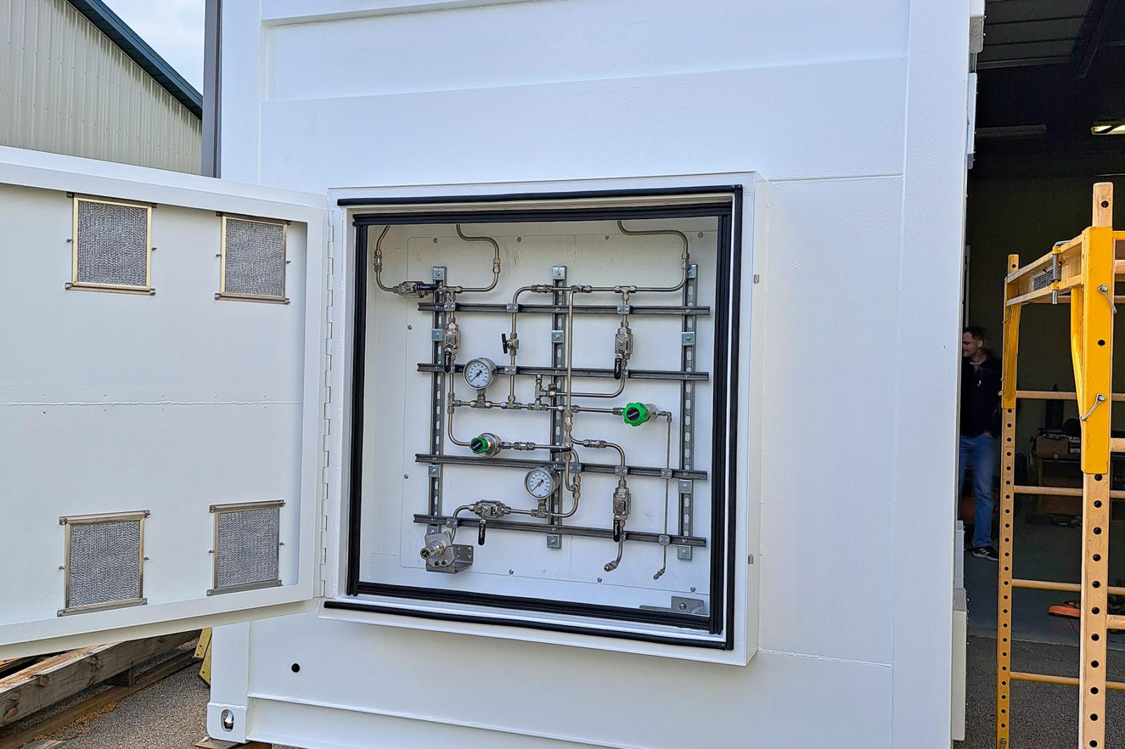 High-pressure gas plumbing and tubing with visible hydrogen safety sensors, pressure relief devices, and regulation valves.