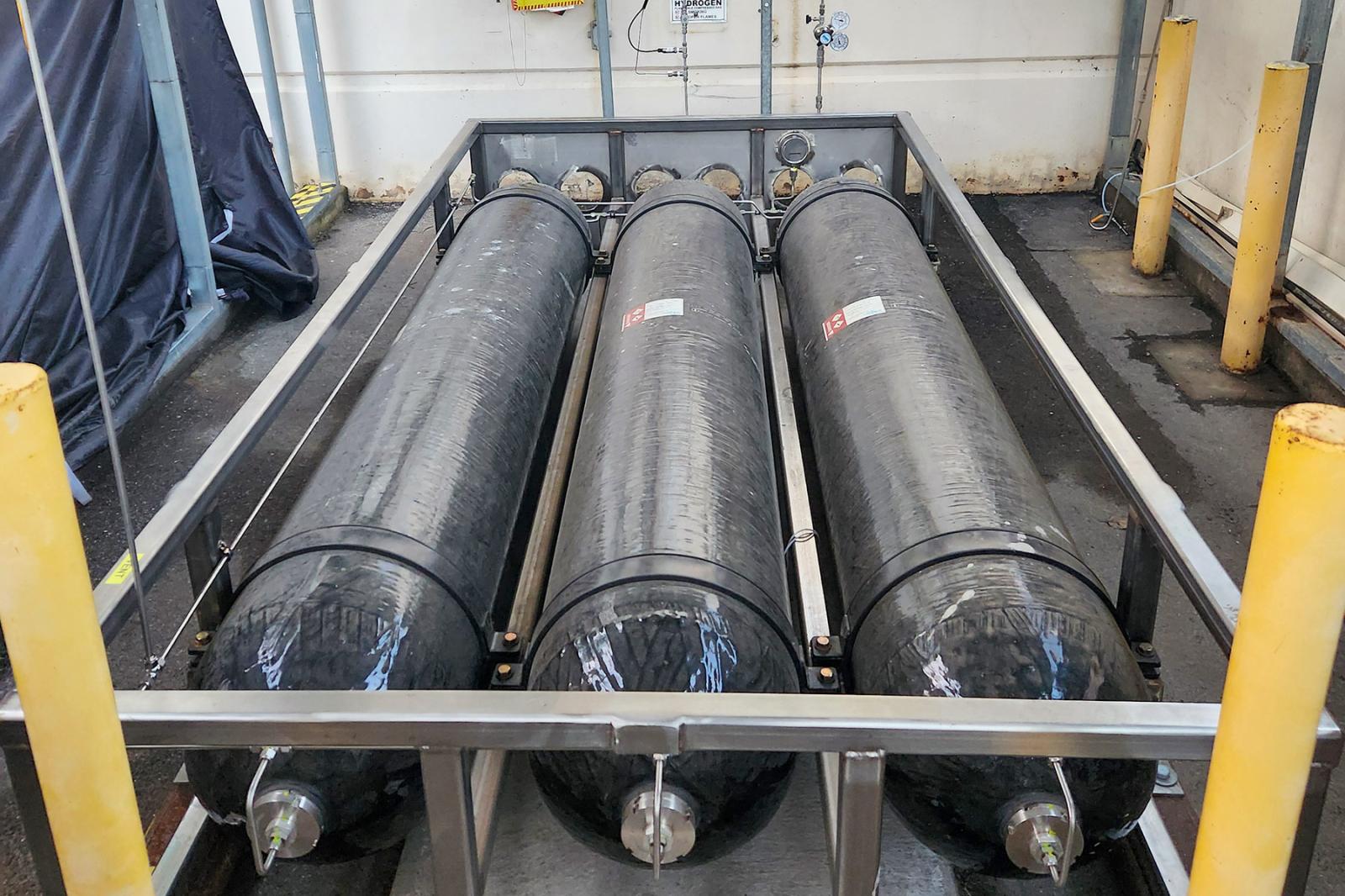 Small-scale hydrogen storage solution using strap-mounted Type 3 composite pressure vessels, ideal for electrolyzer off-gas collection.