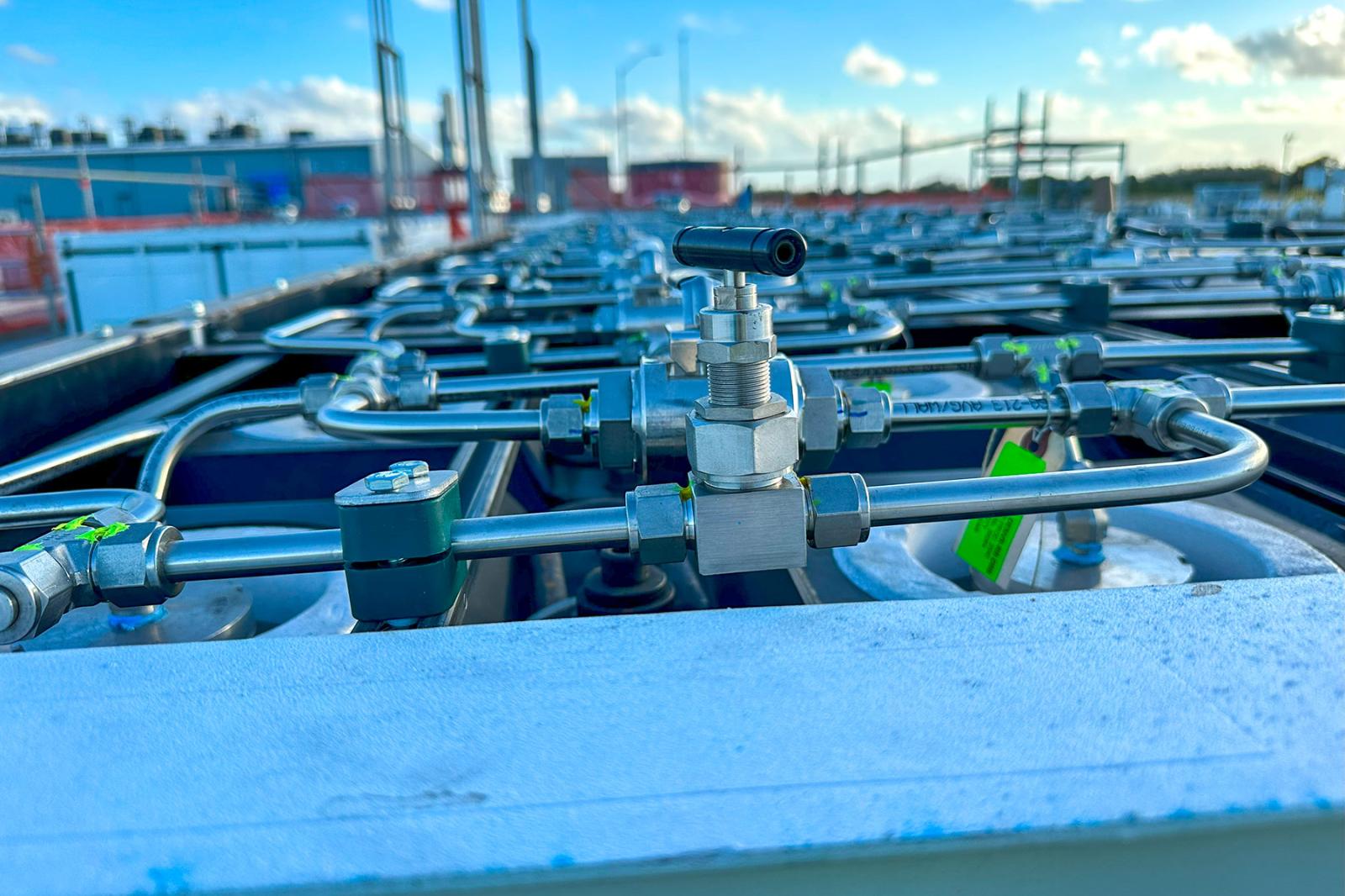 Detail of stainless steel valves and tubing on a HydrogenCube system, showing precision gas flow control for hydrogen storage and distribution.