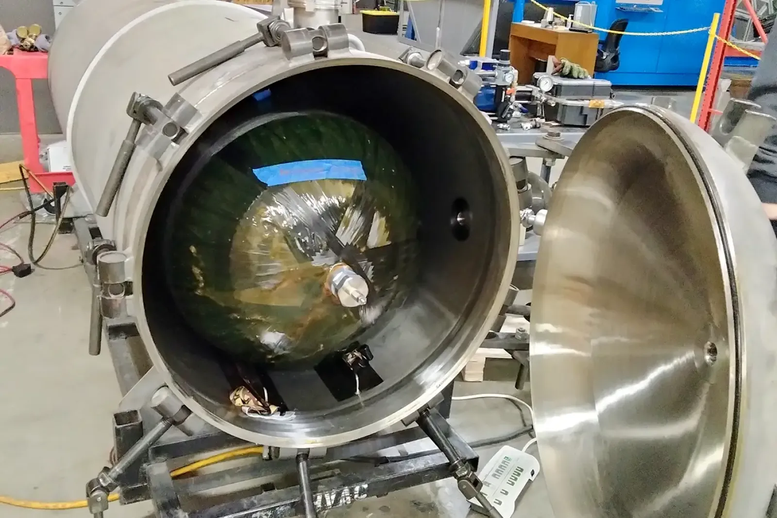 Composite pressure vessel inside a materials testing chamber at Steelhead Composites, used with a 2,200 lb Instron Load Frame, strain gauges, DSC, and 3D laser scanning for ASTM-compliant mechanical testing.