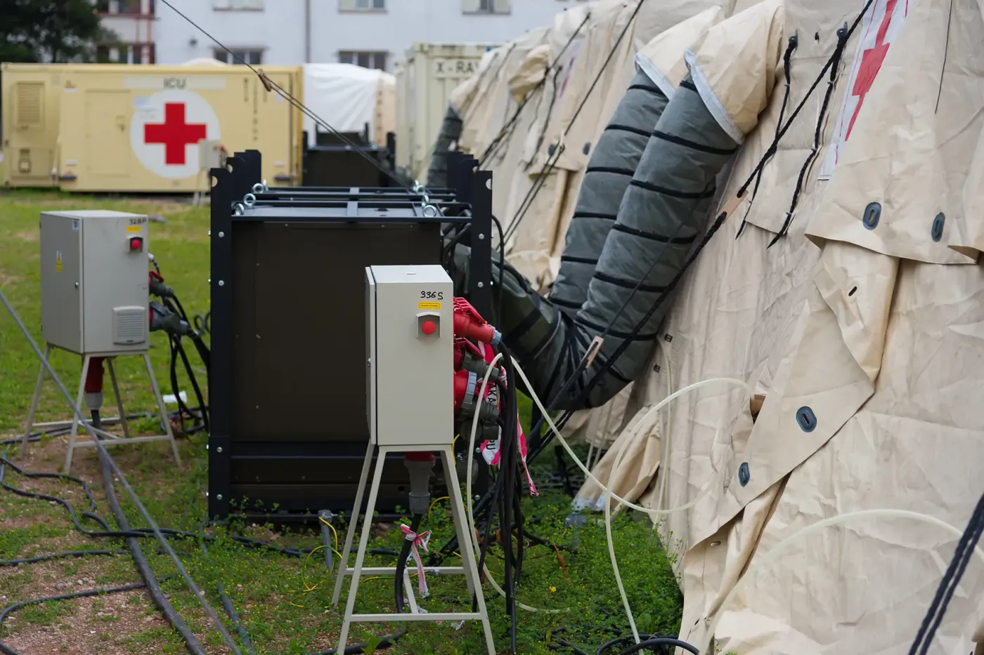 Field-deployed emergency medical tents with power and air supply lines—illustrating life-support and breathable gas delivery systems in mobile trauma care and disaster response.
