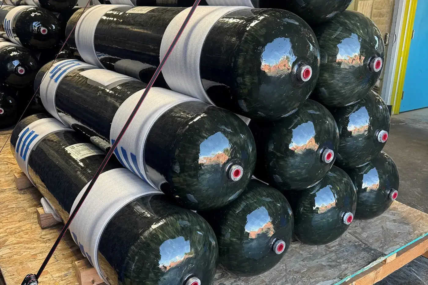 Stack of composite pressure vessels prepared for comparative testing, supporting performance benchmarking of weight, strength, and cost in aerospace applications.