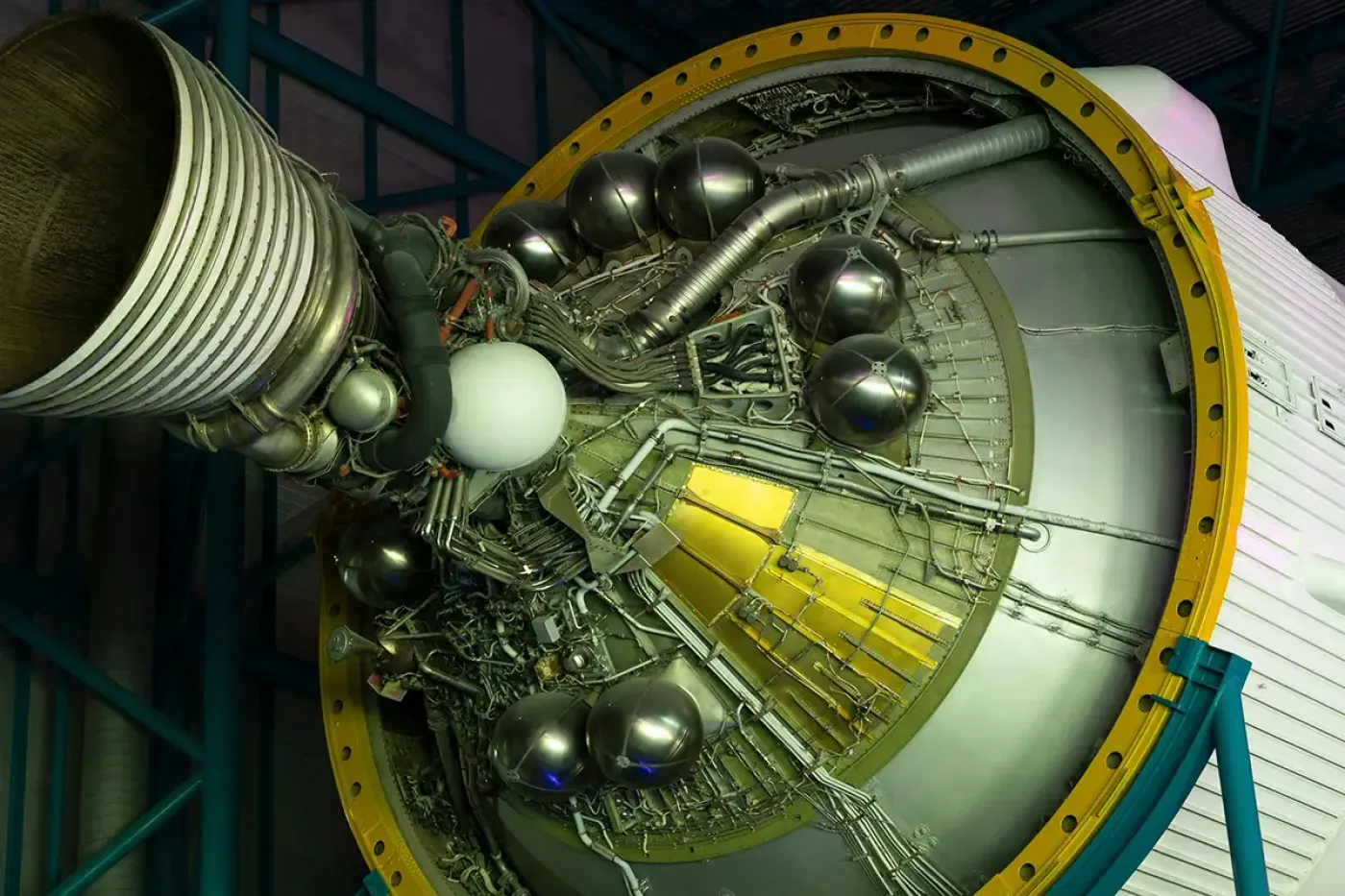 Close-up of a rocket engine stage with complex piping and pressure vessels, representing post-test and post-mission failure analysis to guide design improvements.