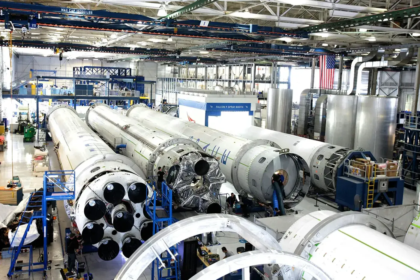 Rocket stages under assembly in a spacecraft production facility, representing S-081 and S-080 qualification testing of pressure vessels for propulsion, life-support, and pressurization systems.