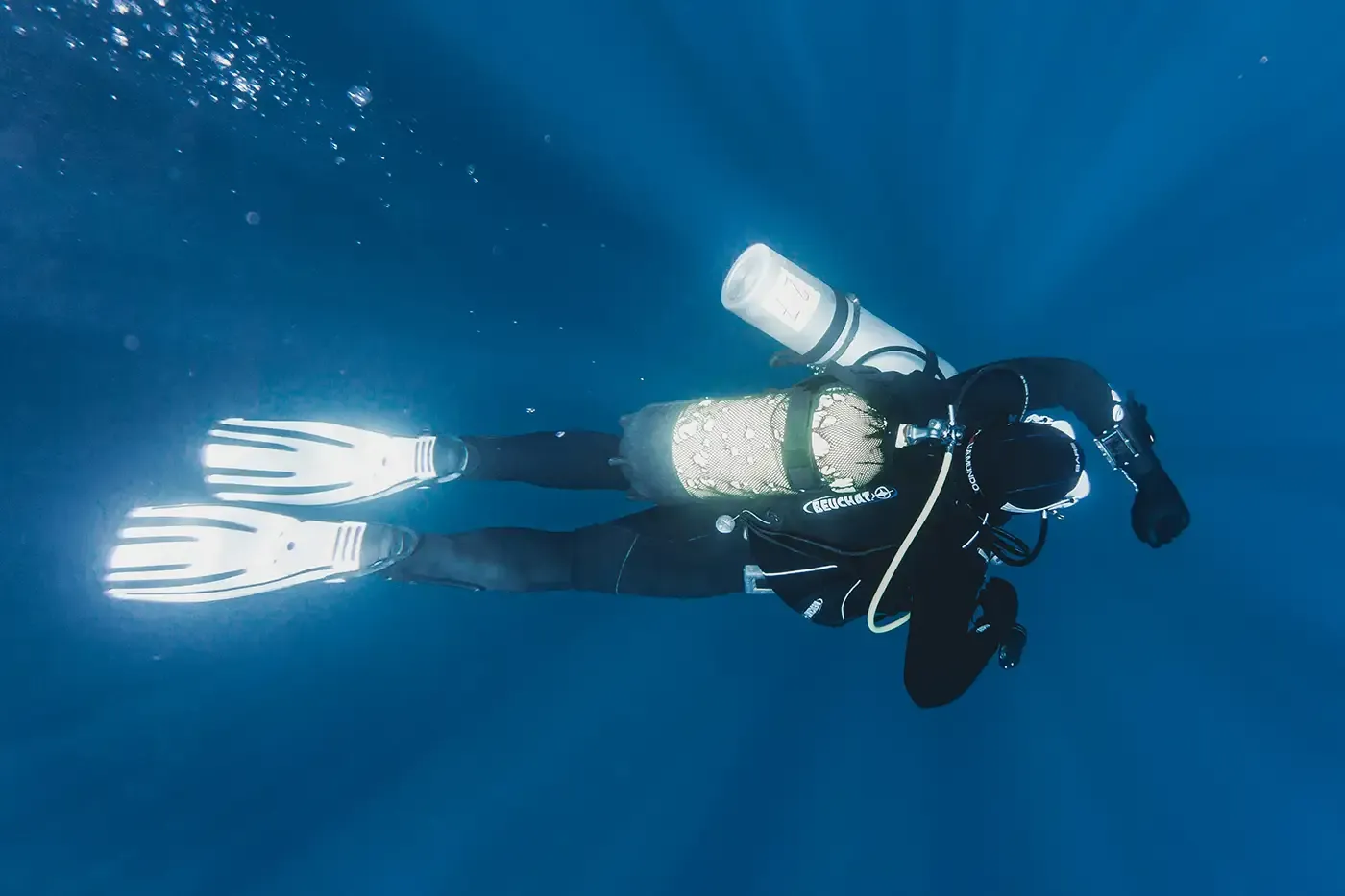 Scuba diver underwater with breathing tank, illustrating SCUBA recertification to extend service life and ensure safety for diving, rescue, and marine research.